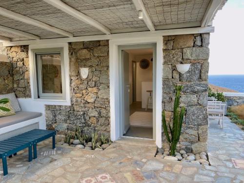 a stone house with a bench on a patio at Bohemian Blue Villa - 7 BDRM - beach in 200m - MG Villas in Panormos Mykonos