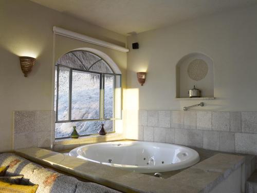 a large bath tub in a room with a window at Arava Land in Zuqim