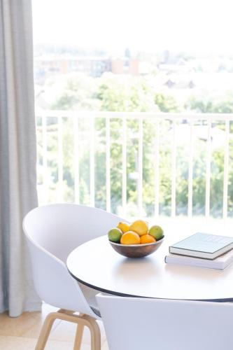 a bowl of fruit on a white table in front of a window at Hotel de Milliano in Breskens