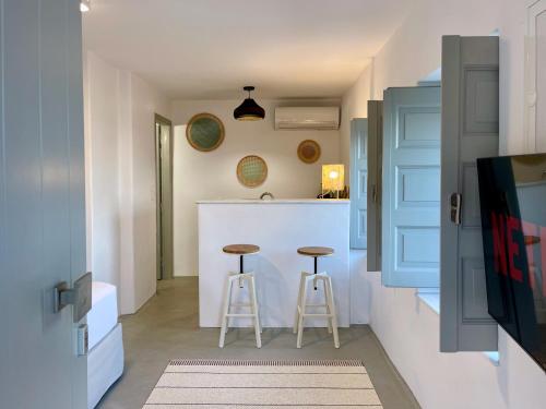 a kitchen with two stools and a white counter top at Bohemian Blue Villa - 7 BDRM - beach in 200m - MG Villas in Panormos Mykonos