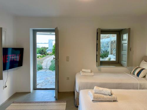 a room with two beds and a mirror on the wall at Bohemian Blue Villa - 7 BDRM - beach in 200m - MG Villas in Panormos Mykonos