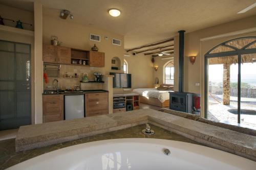 a large bathroom with a tub and a bedroom at Arava Land in Zuqim