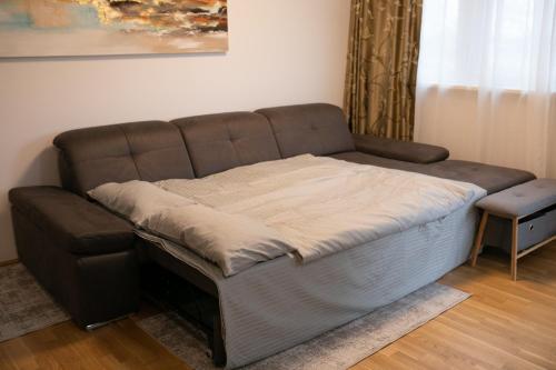 a couch with a blanket on it in a living room at Schönes Living am Donauufer in Vienna