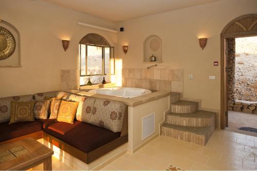 a bathroom with a couch and a bath tub at Arava Land in Zuqim