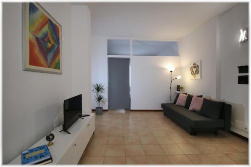 uma sala de estar com um sofá e uma televisão de ecrã plano em [10 min metro] Palavela Suite em Turim
