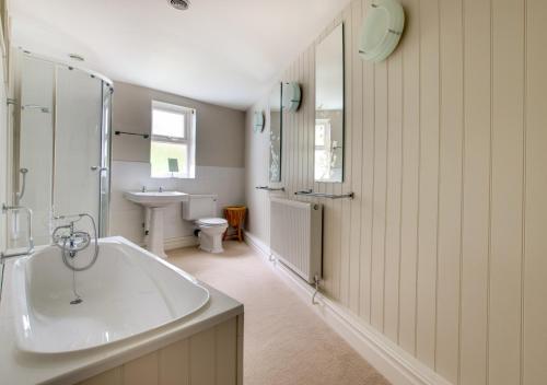 a white bathroom with a tub and a sink at The Old Stores in Ipswich