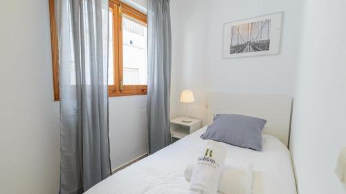 a small bedroom with a bed and a window at Apartamento Almijara Cómpeta by Ruralidays in Cómpeta
