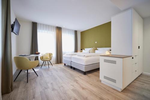 a hotel room with a bed and a desk and a table at Mühlenhelle in Gummersbach