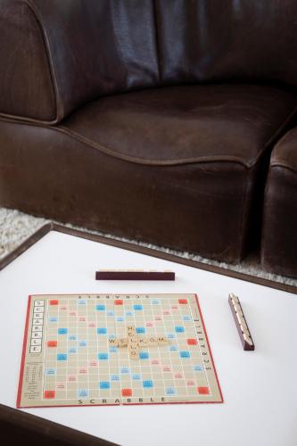 a table with a chess board and a leather couch at Hotel de Milliano in Breskens