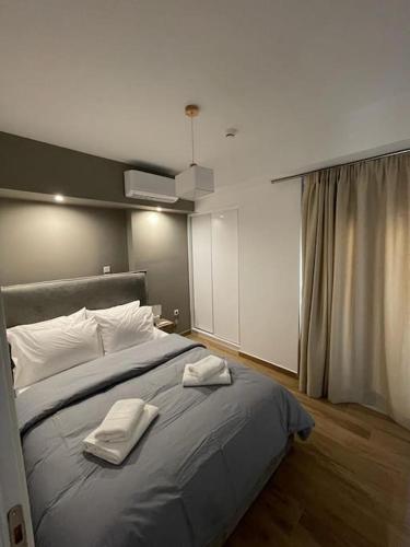 a bedroom with a large bed with two towels on it at Niarchos apartment III in Athens