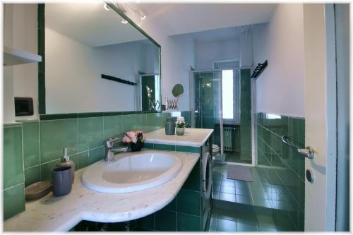 a bathroom with a sink and a large mirror at [10 min metro] Palavela Suite in Turin