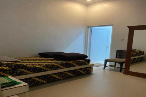a bedroom with a bed and a mirror and a chair at EXPRESS O 91923 Homestay Zona in Sukabumi
