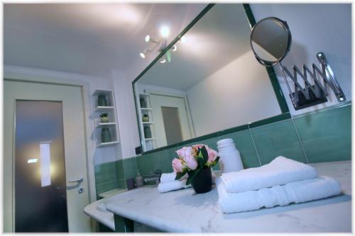 a bathroom with a sink with towels and a mirror at [10 min metro] Palavela Suite in Turin