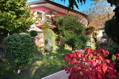 a house with a garden with red flowers at Biser apartmani in Vrdnik