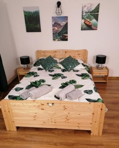 a bedroom with a wooden bed with green and white sheets and pillows at Pokoje gościnne u Majerczyków in Stozh