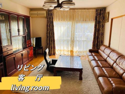 a living room with a leather couch and a coffee table at Amitie Villa in Hannan