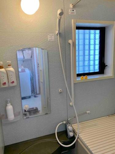 a bathroom with a shower and a mirror at Amitie Villa in Hannan