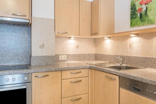 a kitchen with wooden cabinets and a sink at Huterhof Apt Tatschblick in Riobianco