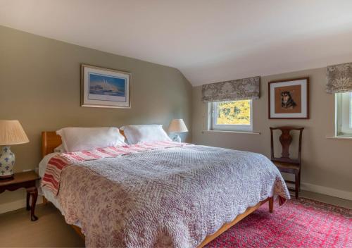 a bedroom with a large bed and two windows at The Pightle in Parham