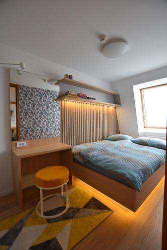 a bedroom with a bed with a desk and a stool at Splendid View Place in Jahorina
