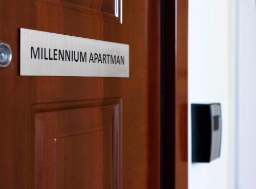 um sinal numa porta que lê millilum apartmentarian em Millennium Apartman Tatabánya em Tatabánya