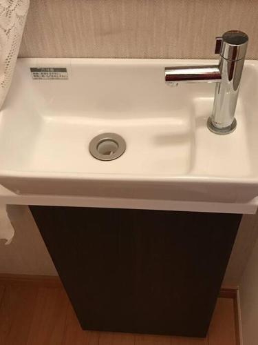 a white bathroom sink with a silver faucet at Amitie Villa in Hannan