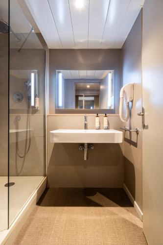 a bathroom with a sink and a shower at Mercure Grenoble Meylan in Meylan