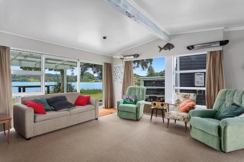 a living room with two couches and two chairs at Harbourside - Ohope Holiday Home in Ohope Beach