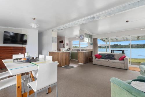 a living room with a kitchen and a dining room at Harbourside - Ohope Holiday Home in Ohope Beach