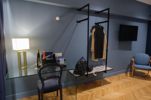 アテネにあるK23 Color Suitesのガラスのテーブルと椅子が備わる客室です。