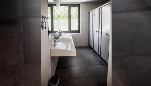 a bathroom with two sinks and a window at Hotel Garni Fischerfleck in Ismaning near Munich in Ismaning
