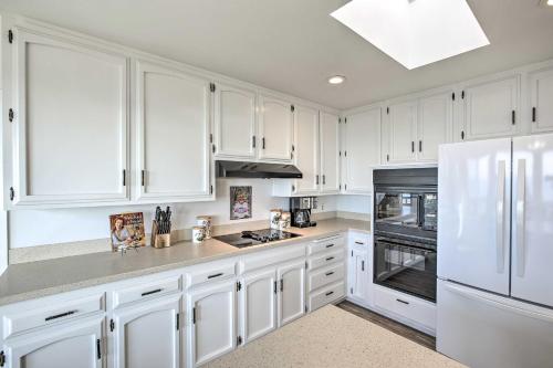 a white kitchen with white cabinets and a refrigerator at Pet-Friendly Cayucos Home with Ocean Views! in Cayucos