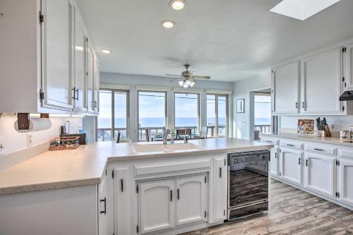 a kitchen with white cabinets and a large window at Pet-Friendly Cayucos Home with Ocean Views! in Cayucos