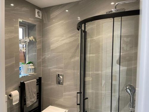 a bathroom with a shower with a glass door at Lamorna in Littlehampton
