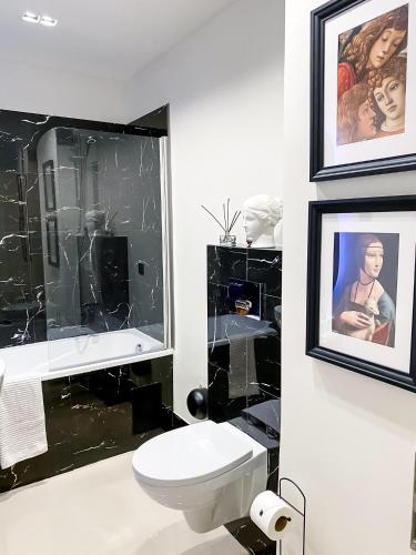 Baño en blanco y negro con aseo y espejo en AD Boutique Apartment, en Budapest