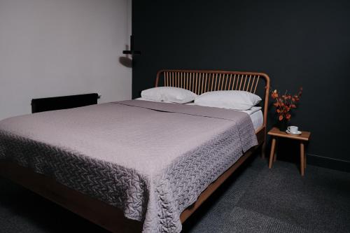 a bedroom with a bed and a table with a night stand at Vanadziņa māja in Cēsis