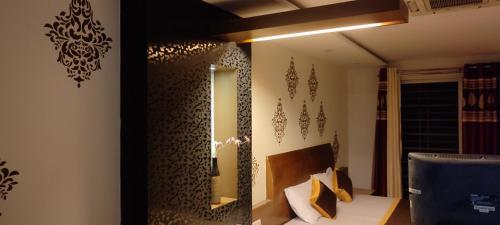 Habitación con cama y espejo en la pared. en Happy Vibes Nest-studio flat, en Vānivilāsa Puram