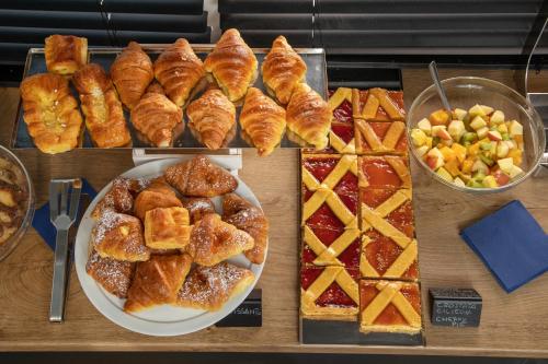 a table topped with plates of pastries and other foods at Bloom Hotel Rome in Rome