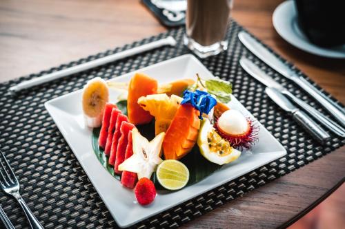 a plate of fruits and vegetables on a table at Saltasia Boutique Beach Villa in Mirissa
