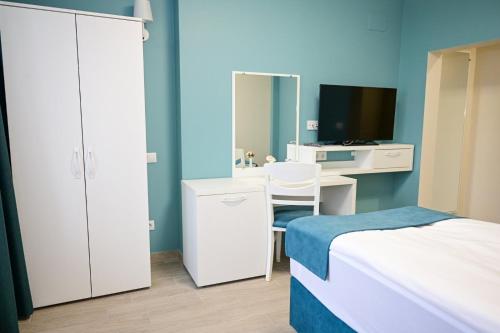 a bedroom with a bed and a desk and a mirror at Роял Шумен in Shumen