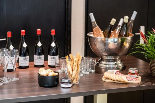 a table with bottles of wine and wine glasses at Mercure Grenoble Meylan in Meylan