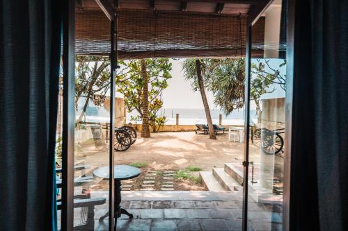 a room with a view of the beach through a window at Saltasia Boutique Beach Villa in Mirissa