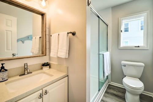 Un baño con inodoro, lavabo y espejo. en Oceanside Oak Island Getaway For Families and Pets!, en Oak Island
