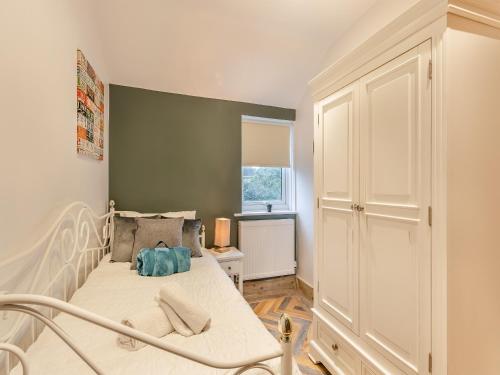 1 dormitorio con cama blanca y ventana en Kings Retreat, en Oakham