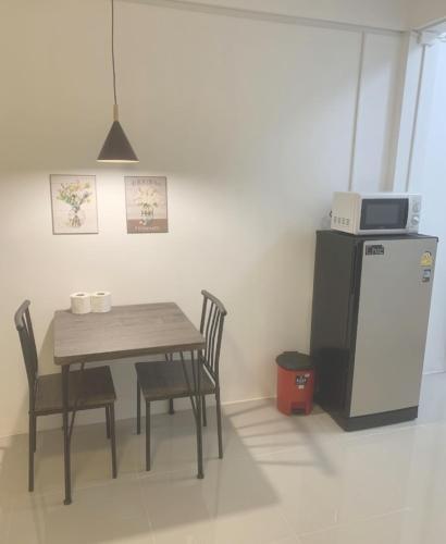 a dining room with a table and a refrigerator at Barzilla Bar And Guesthouse in Pattaya