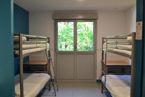 two bunk beds in a room with a window at Centre International de Séjour in Laval