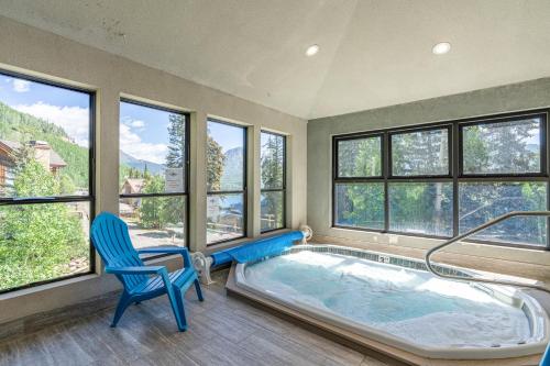 a room with a hot tub with a chair and windows at Angelhaus #300 in Durango Mountain Resort
