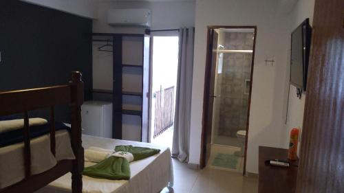 a bedroom with a bed and a balcony with a shower at Hotel Pousada Rio Mar in Ubatuba