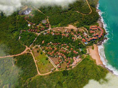 an island with houses on the shore of the ocean at Buzios Espiritualidade Hotel in Búzios
