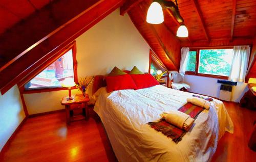 ein Schlafzimmer mit einem großen Bett im Dachgeschoss in der Unterkunft LADERAS DEL CAMPANARIO in San Carlos de Bariloche